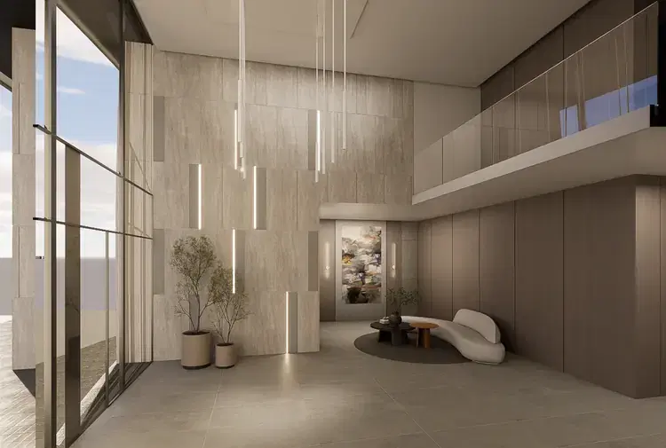 Render del hall de acceso, con materiales pétreos y luz cálida.